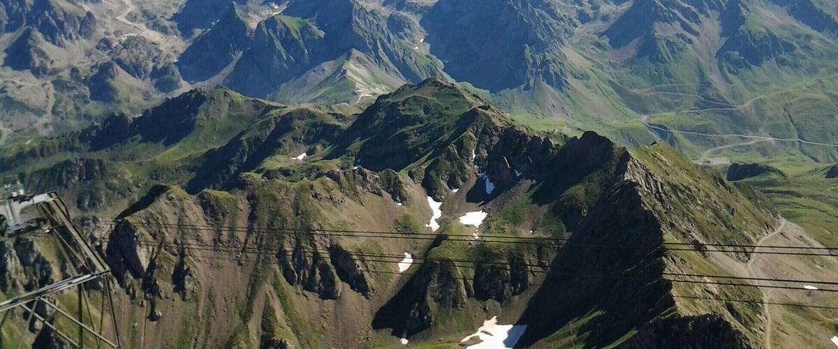 A mountainous landscape with rugged peaks and patches of snow.