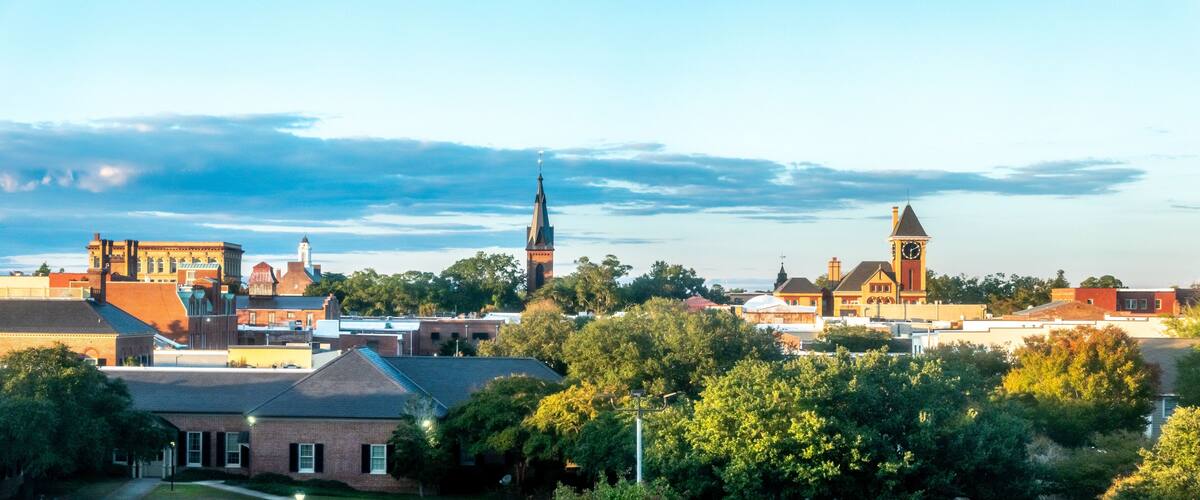 A town with historic buildings, a prominent church steeple, and a clock tower.