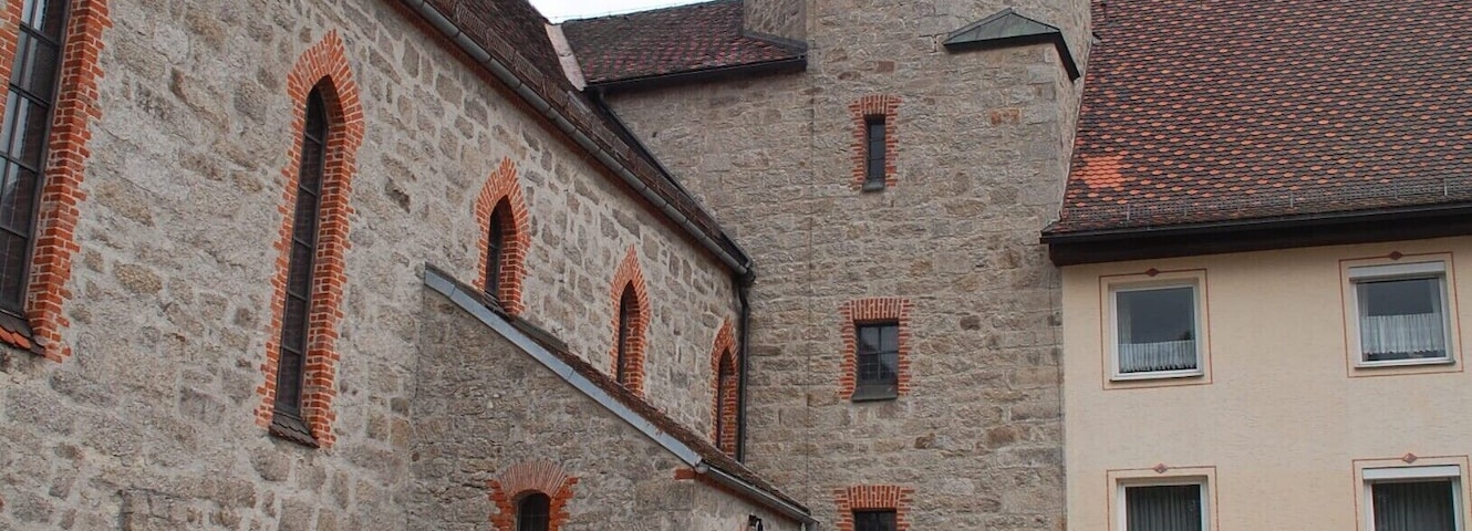 Well kept church and grounds in the village of Haidmühle in Germany, near the border with Czech Republic. The area is popular with cyclists and hikers.
In Haidmühle there are a few guesthouses, bakeries, and a small supermarket. 
It's a 15 minute walk to the Nove Udoli train station on the Czech side of the border.