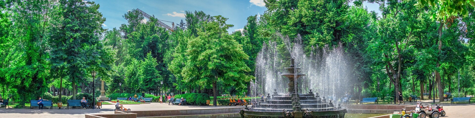 Un parque con una fuente central rodeada de árboles y bancos.