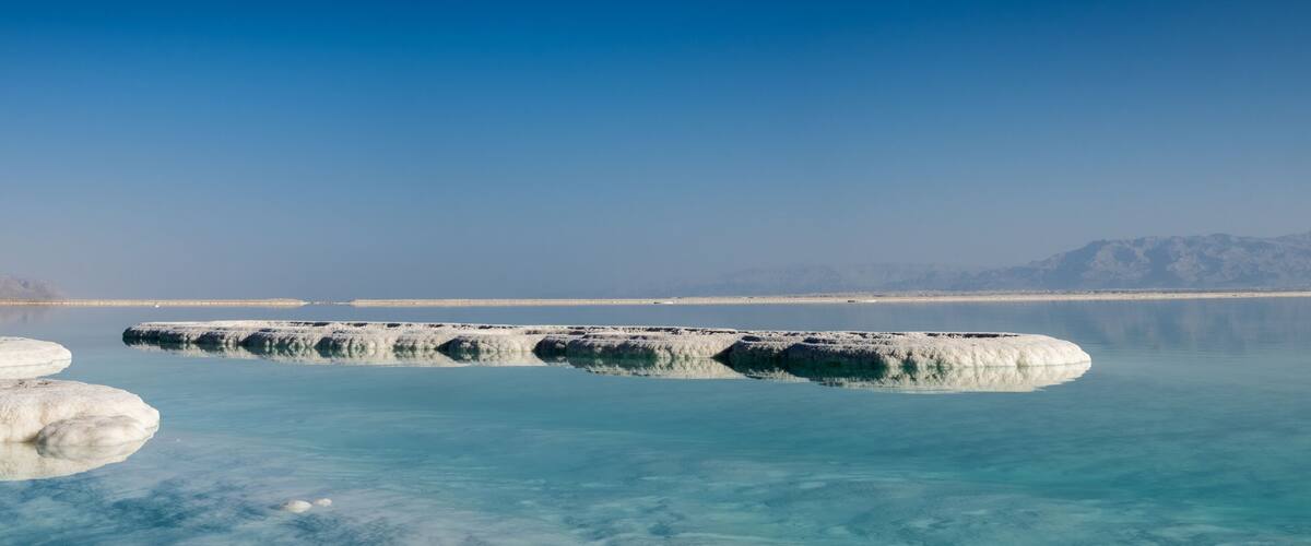 Panoramic view of dead sea salt on beach at sunrise. Israel