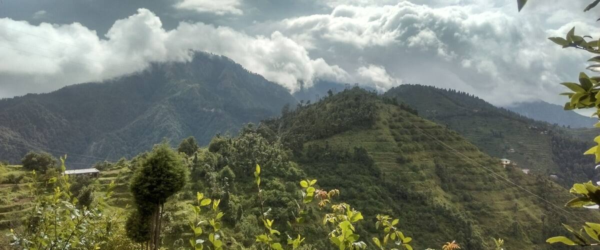 A mountainous landscape with lush greenery and scattered houses.