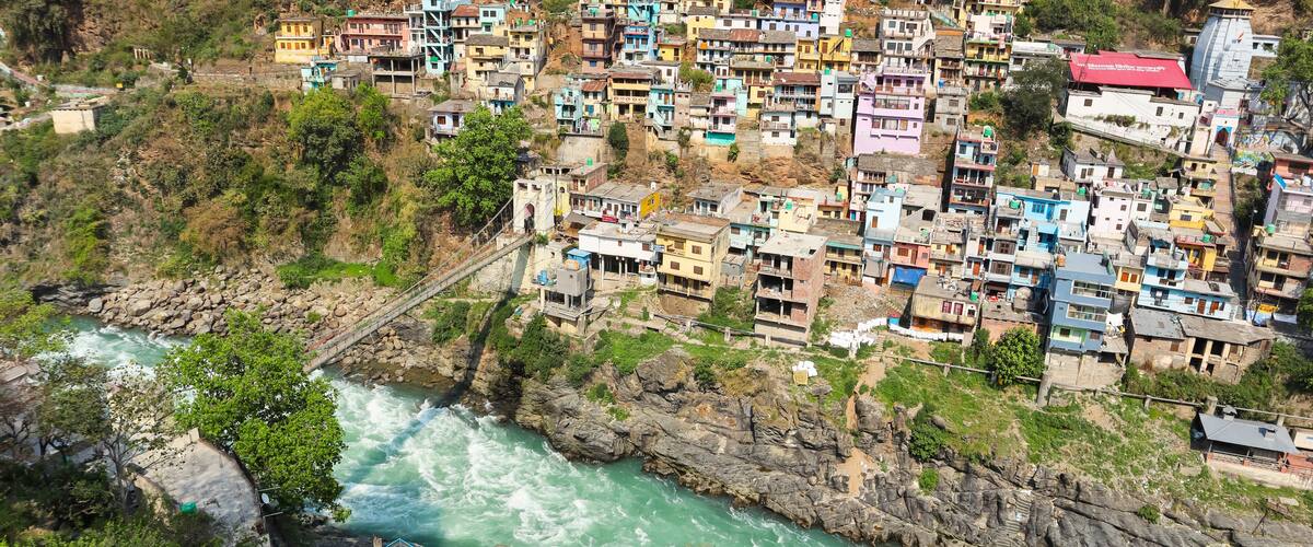 A hillside village with colorful houses and a river flowing below.