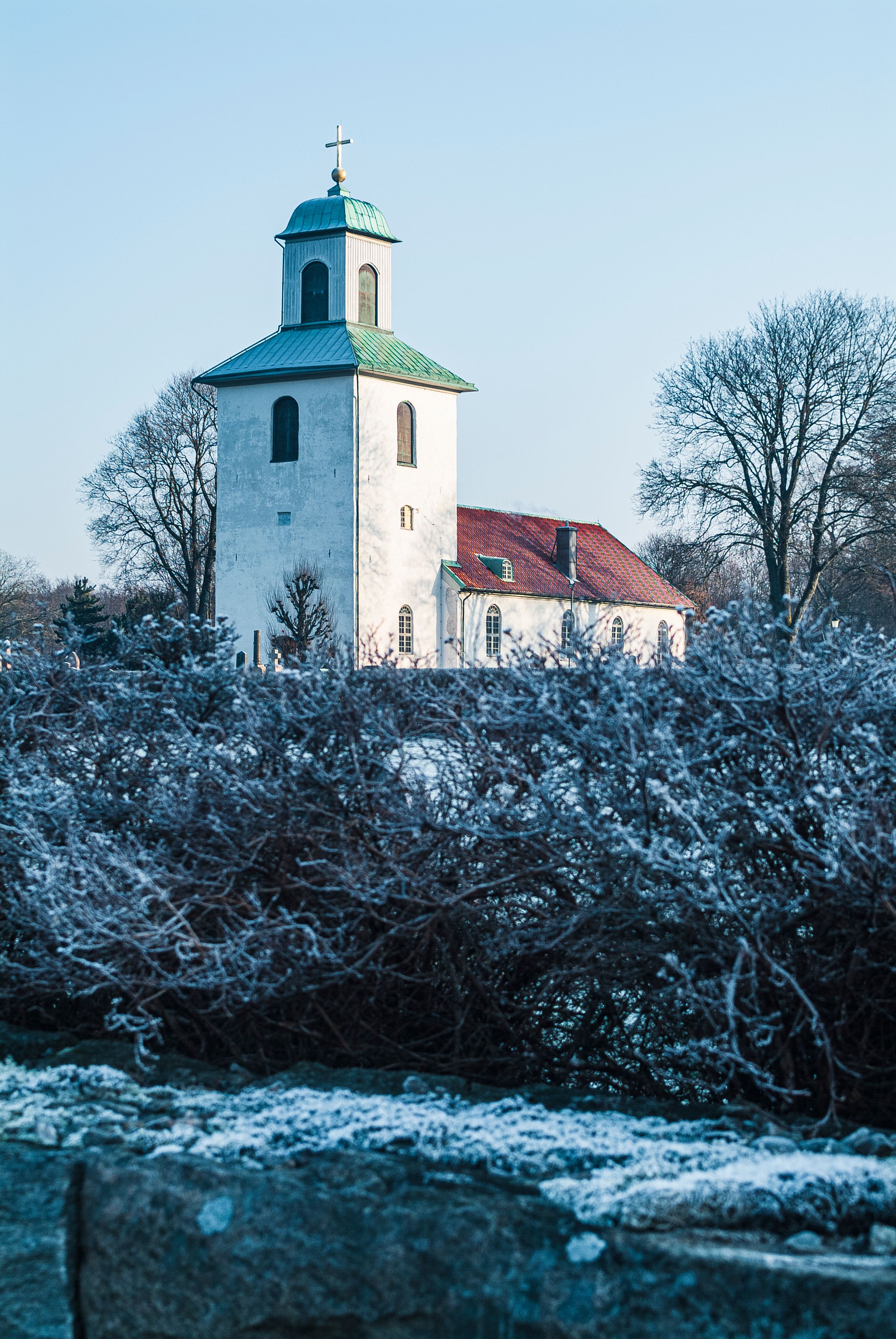 Beautiful winter view of the church in Landvetter, Sweden surrounded by frost-covered vegetation
