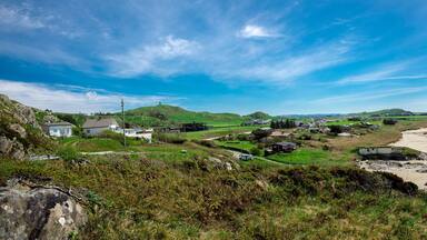 Panoramic view of a long Hellestostranden sand beach and surrounding area with green hills and fields near Stavanger city, Norway, May 2018