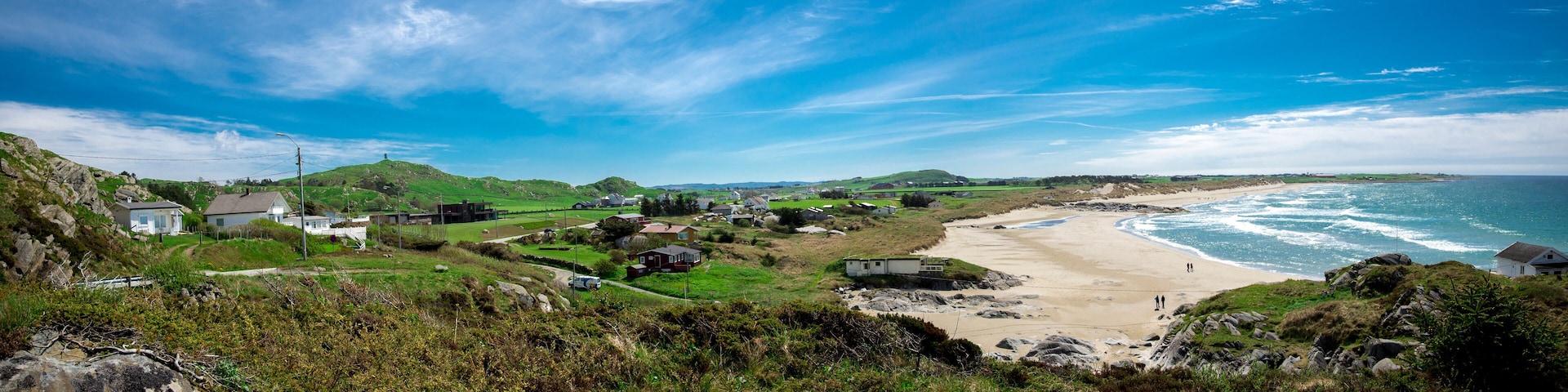 Panoramic view of a long Hellestostranden sand beach and surrounding area with green hills and fields near Stavanger city, Norway, May 2018