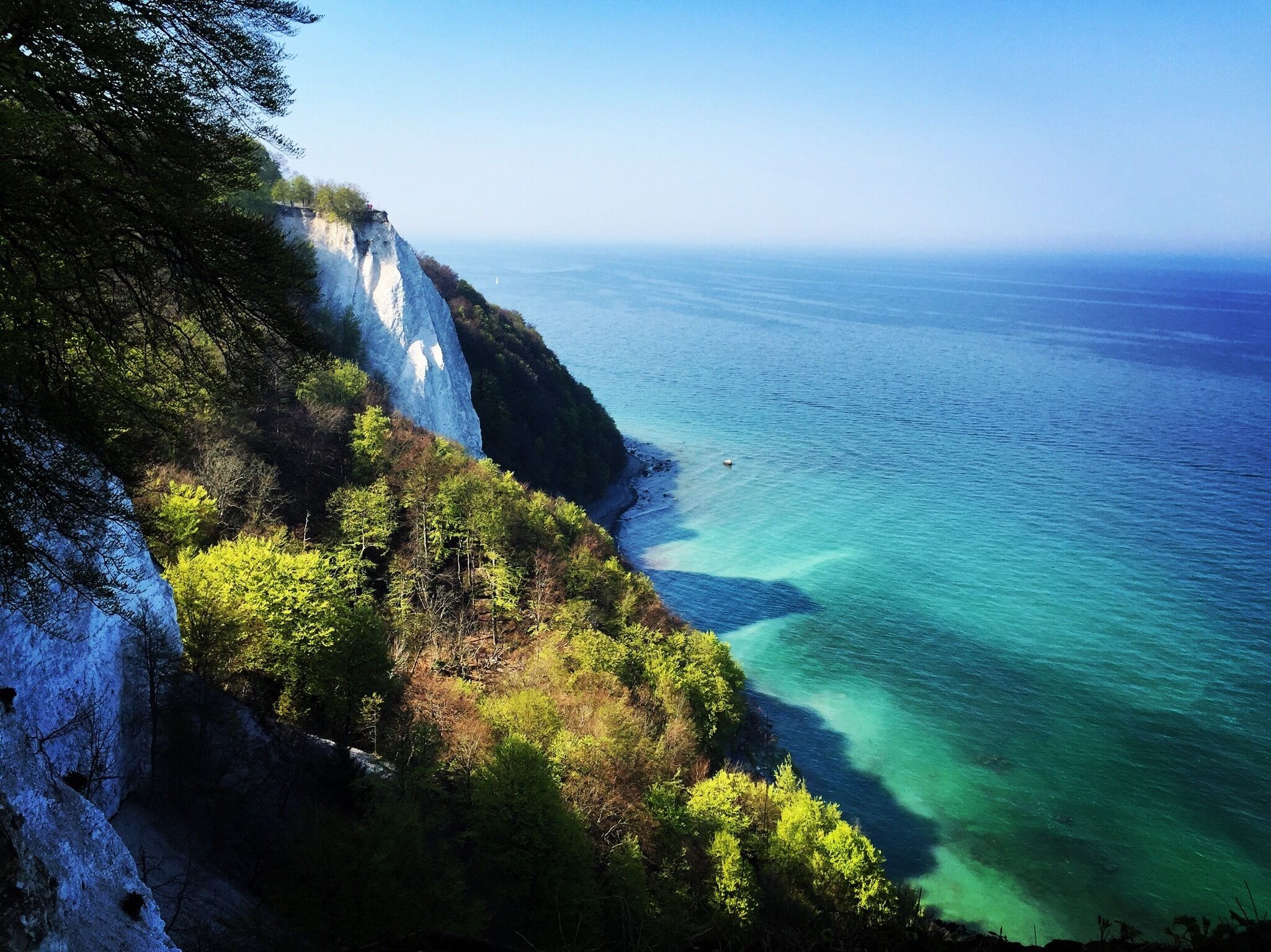 A coastal cliff with a clear view of the ocean.