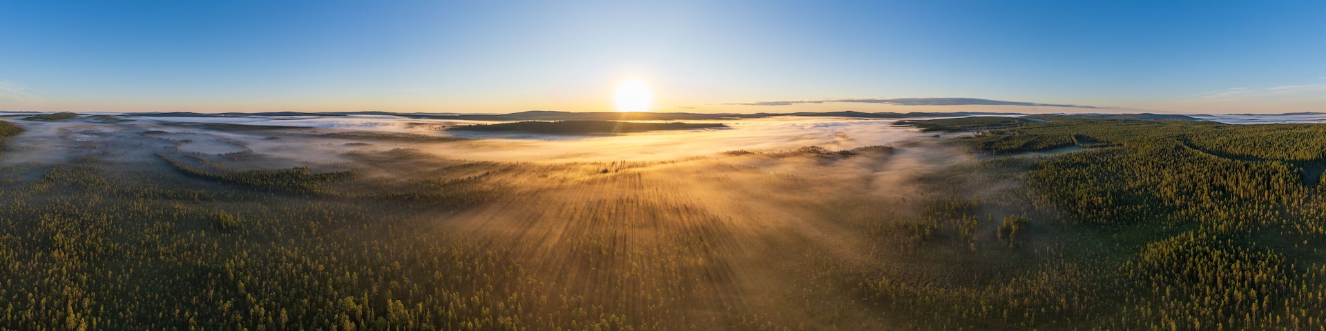 Sonnenaufgang über von Bodennebel bedecktem See und Wäldern in Lappland, Västerbotten, Schweden