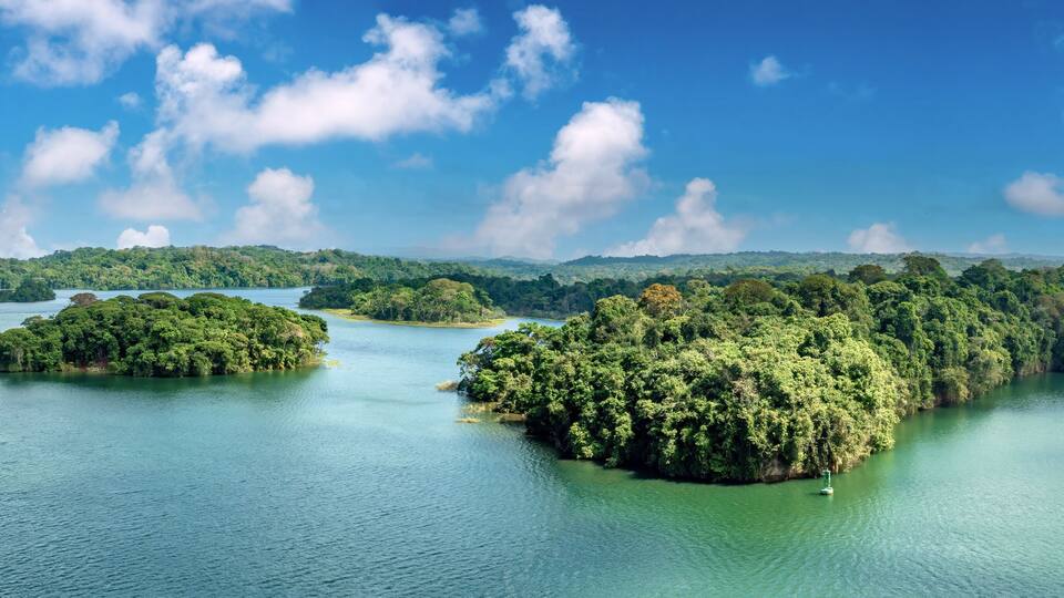 A tropical island landscape with lush greenery and clear blue waters.
