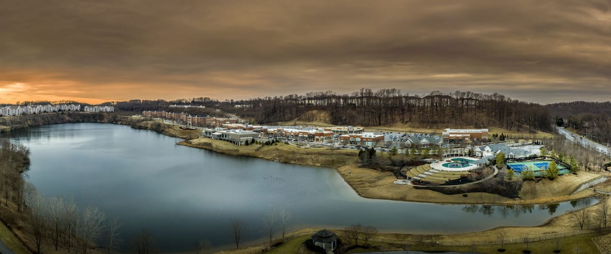 A river winding through a residential area with houses and a large building complex.