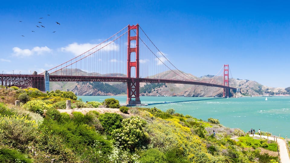 The Golden Gate Bridge spanning a bay with a clear sky.