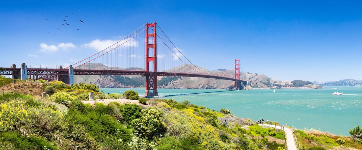 The Golden Gate Bridge spanning a bay with a clear sky.