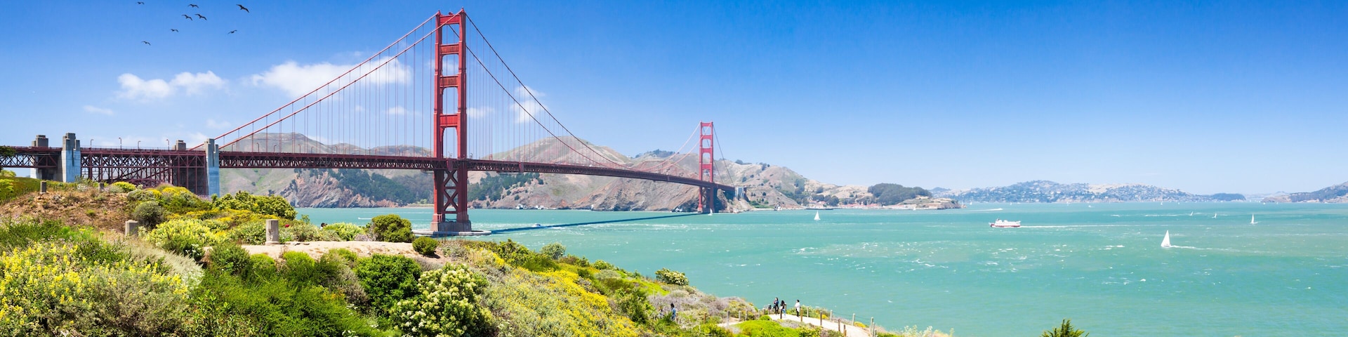 The Golden Gate Bridge spanning a bay with a clear sky.
