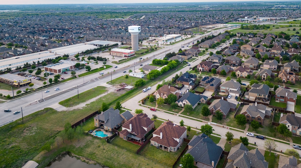 Aerial view of suburban neighborhood with houses roads commercial buildings and water tower