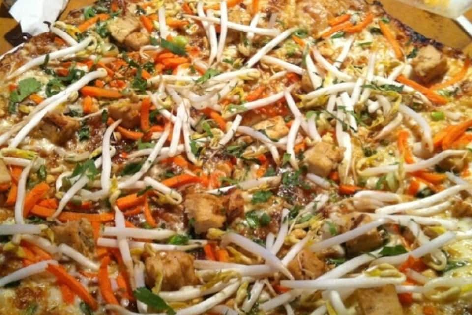 A pizza topped with vegetables and chicken.