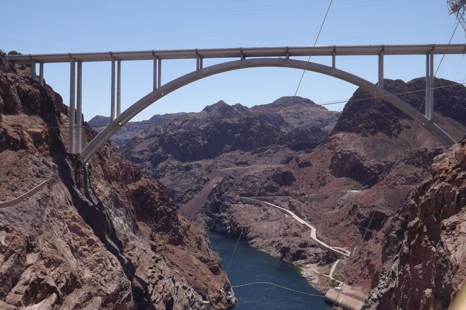 A bridge over a river in a rocky canyon.
