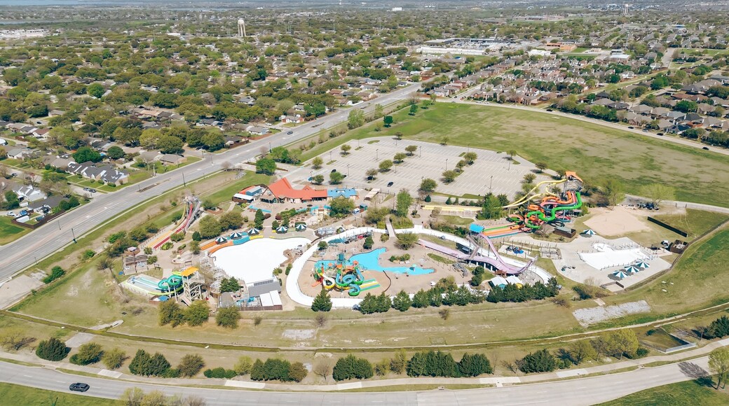 Large water park tropical theme aquatic complex near residential neighborhood of fast-growing Dallas suburbs, The Colony, Denton County, Texas, colorful slides, pools, Lewisville Lake background