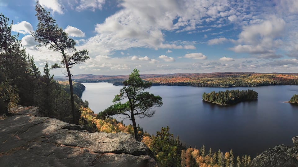 A lake surrounded by autumn-colored trees and rocky terrain.