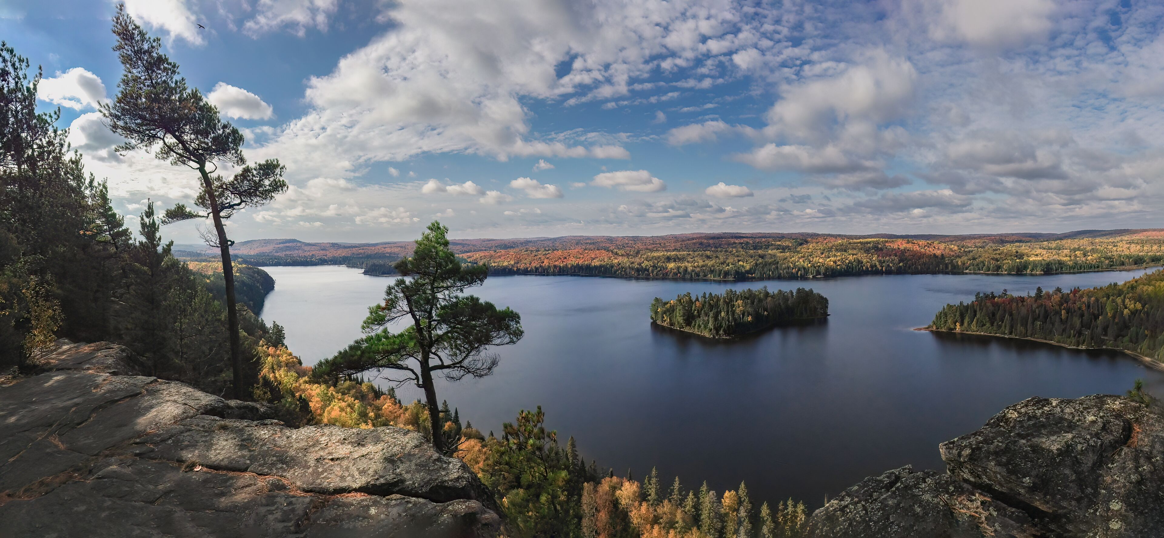 A lake surrounded by autumn-colored trees and rocky terrain.