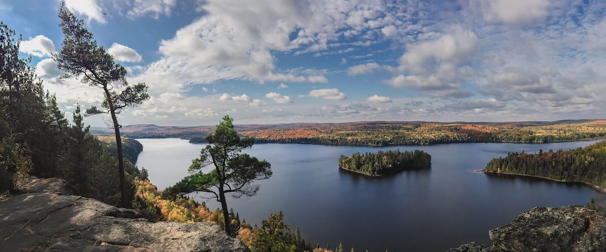 A lake surrounded by autumn-colored trees and rocky terrain.