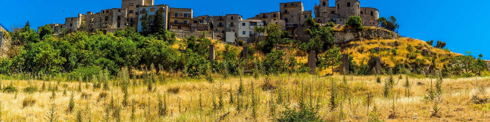 The hilltop village of Petralia Soprana against the backdrop of a bright blue sky in the Madonie Mountains, Sicily during summer