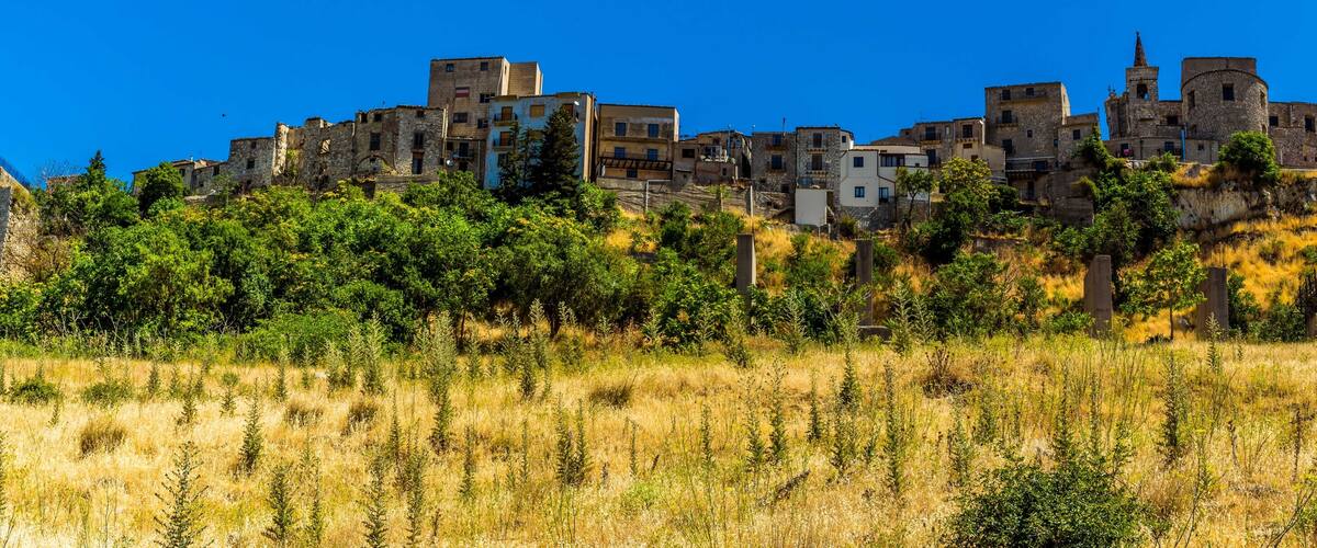 A historic town with stone buildings and a prominent castle on a hill.