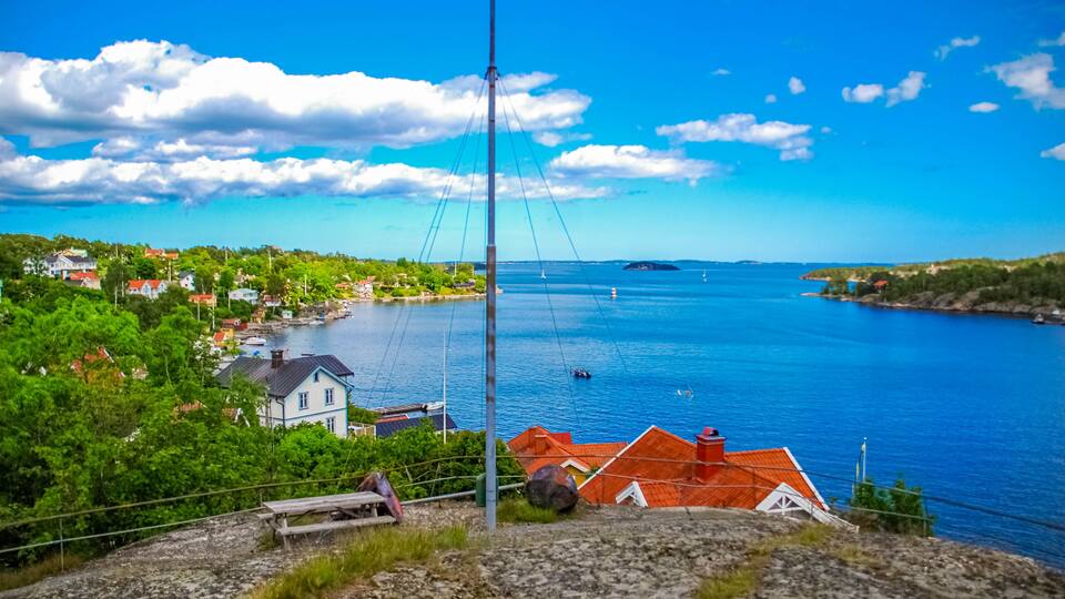 A coastal town with houses, a bridge, and a clear blue sea.