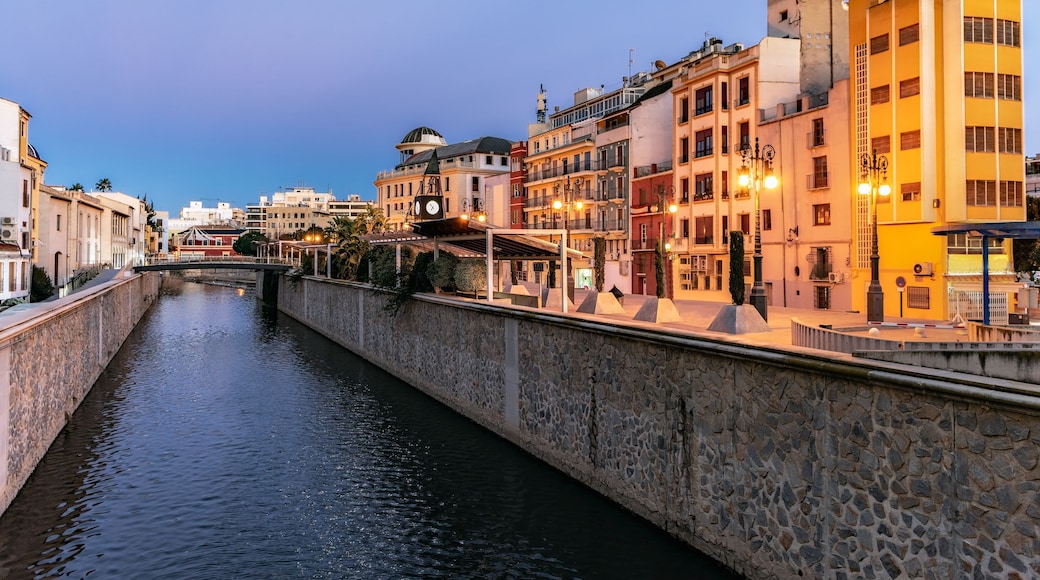 Un canal bordé de murs en pierre, des bâtiments dotés de balcons et un ciel dégagé.