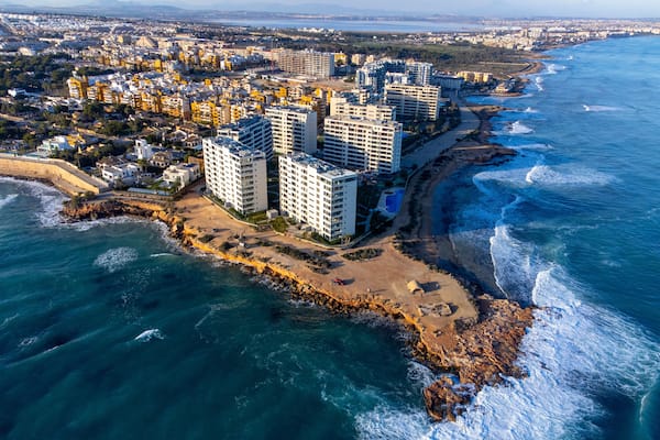 Un paisaje urbano costero con edificios altos, una playa y el océano.