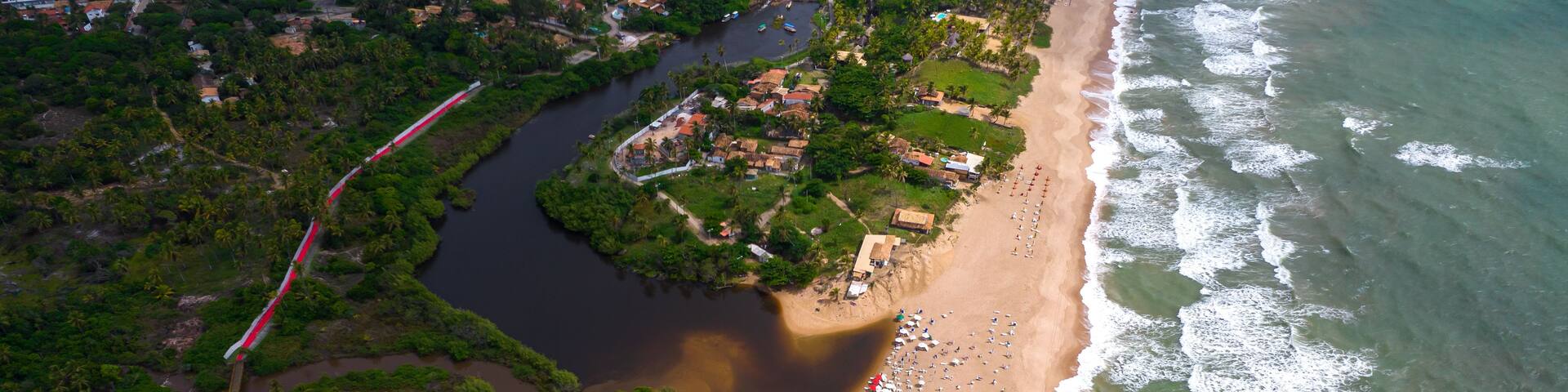 Aerial view of Imbassai beach, Bahia, Brazil. Beautiful beach in the northeast with a river and palm trees.