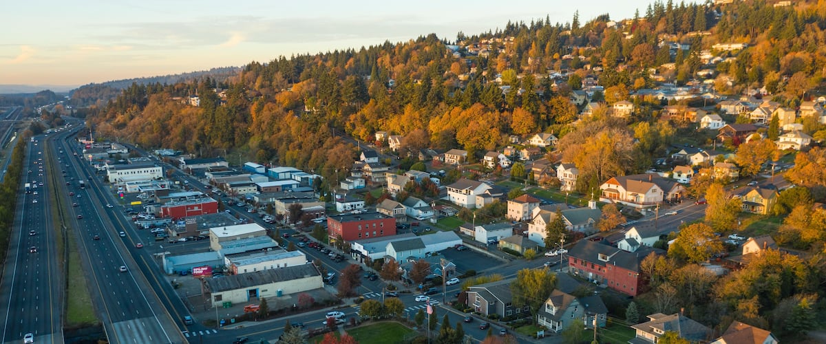 A suburban area with a highway, residential houses, and autumn-colored trees.