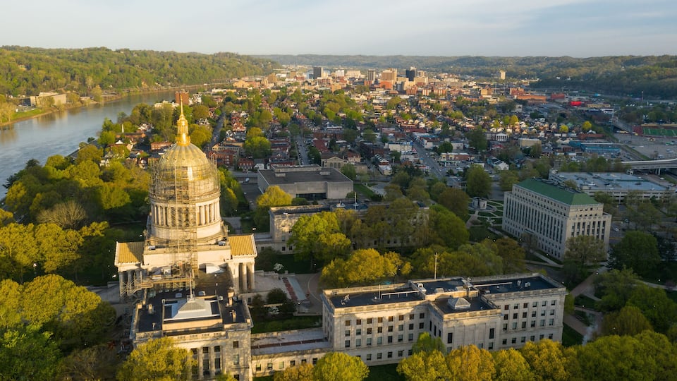 A cityscape with a prominent dome structure, a river, and surrounding greenery.