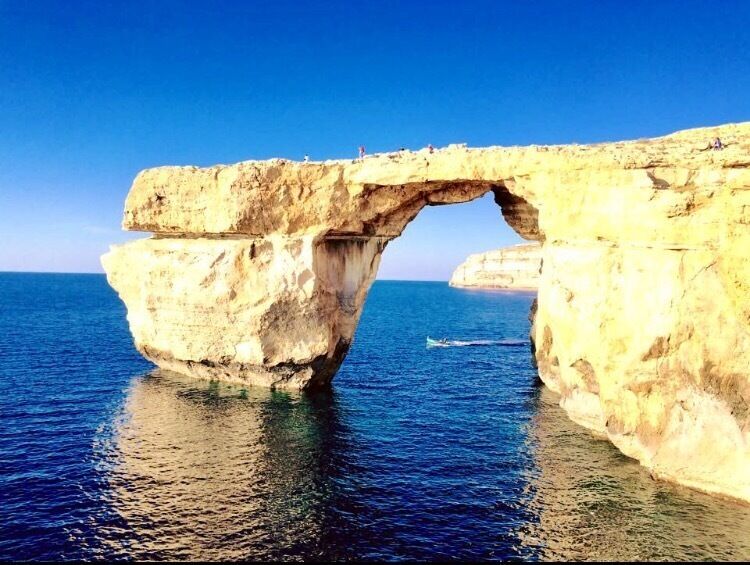 A natural rock arch over the sea.