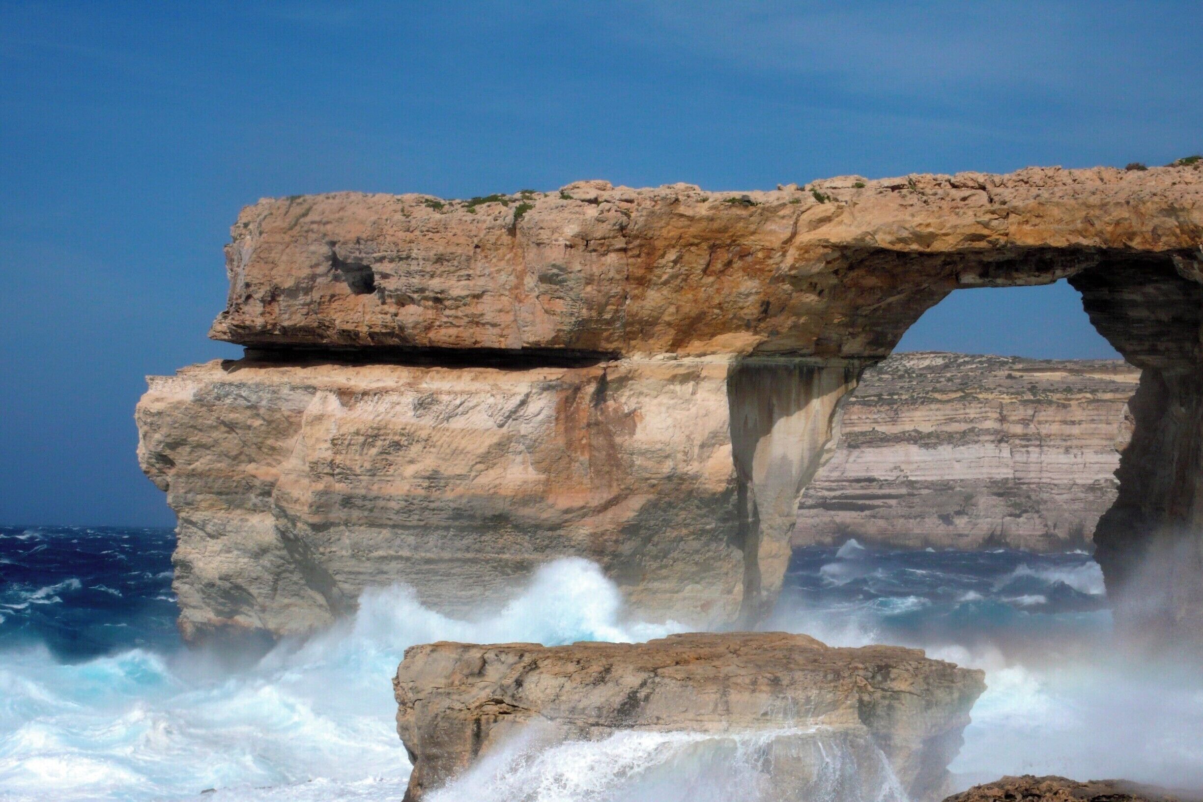 Howling winds whip up vicious waves in the usually tranquil #blue waters beneath the Azure Window on the island of Gozo, where layers of limestone - originally deposited on the seafloor - rise up from the Mediterranean. #BestOf5