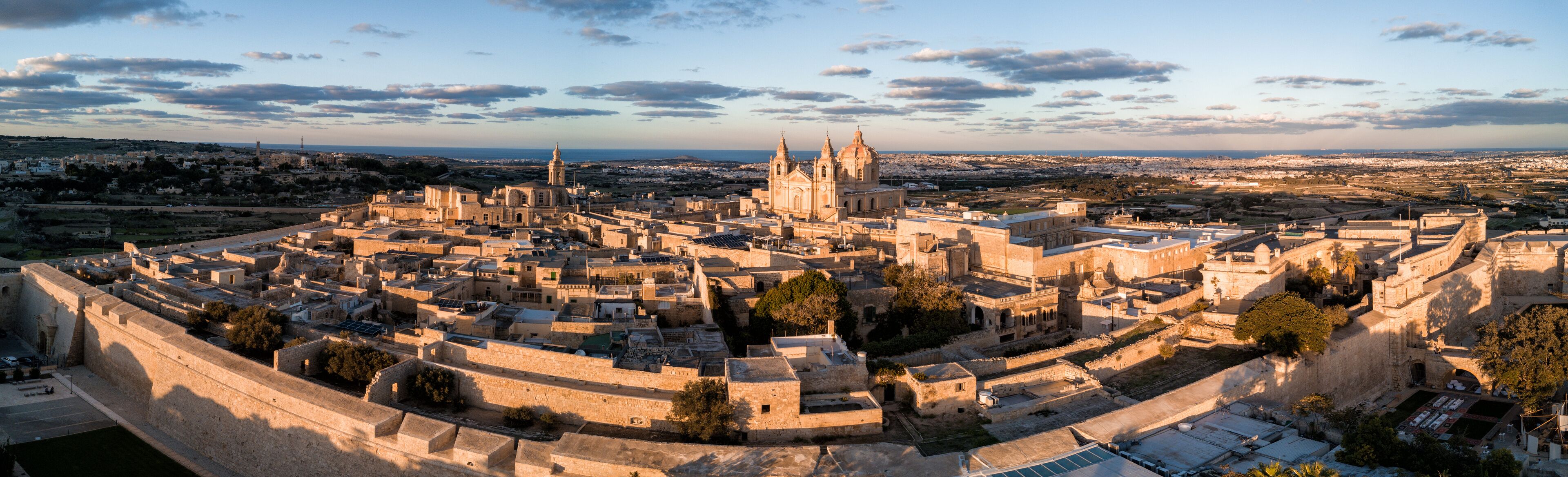 Una ciudad histórica amurallada con una catedral destacada y edificios circundantes.