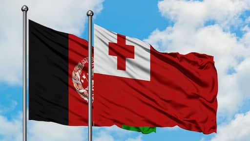 Afghanistan and Tonga flag waving in the wind against white cloudy blue sky together. Diplomacy concept, international relations.
