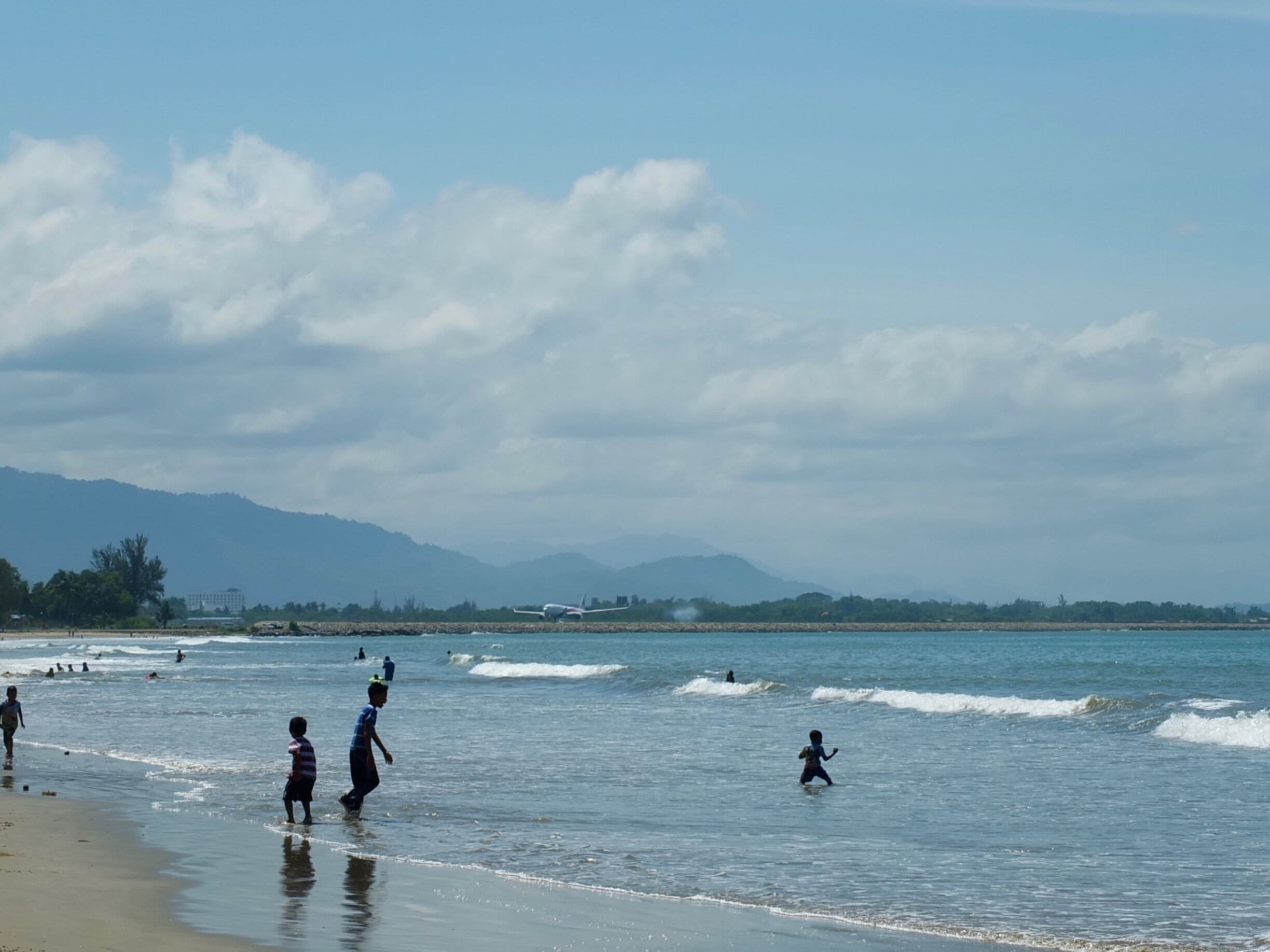 A flight takes off from the Kota Kinabalu airport as seen from Tanjung Aru beach
