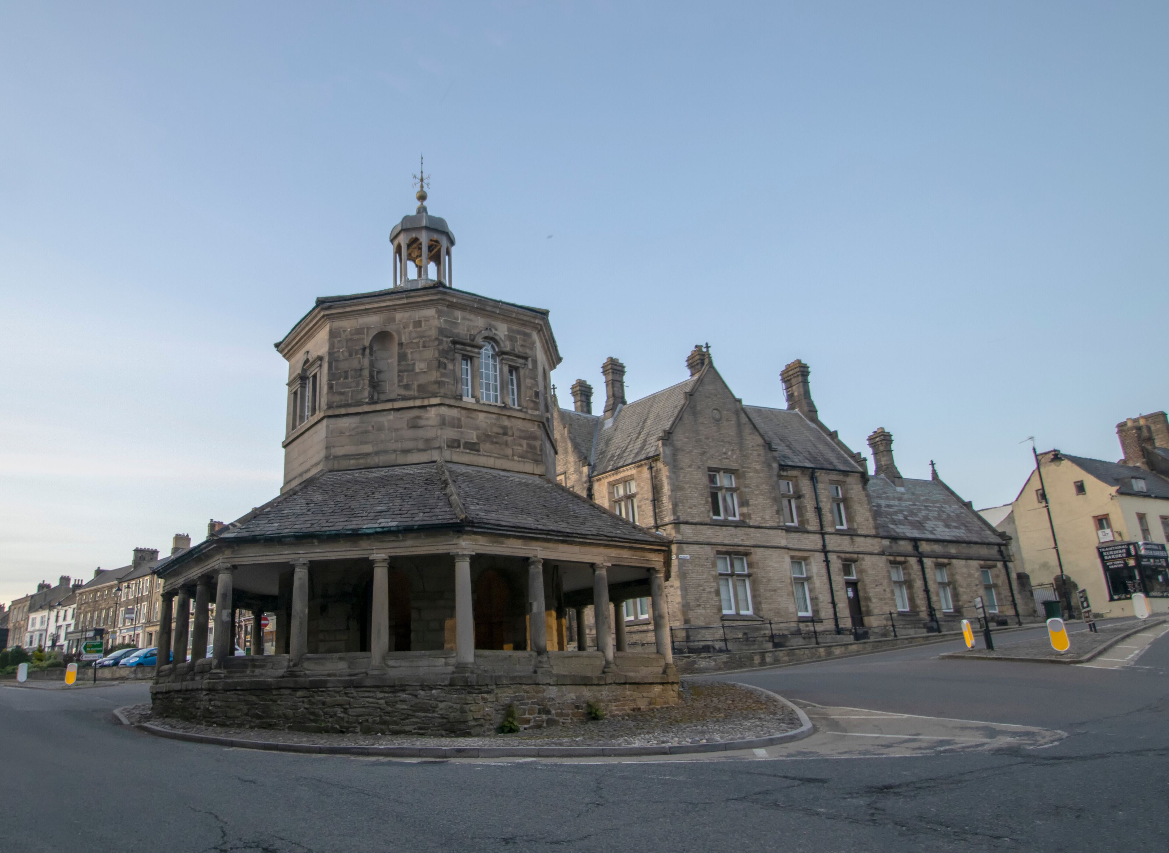 A historic stone building with a tower and a covered porch.