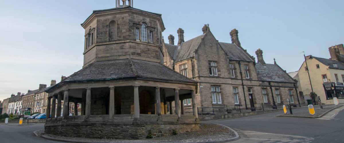 A historic stone building with a tower and a covered porch.