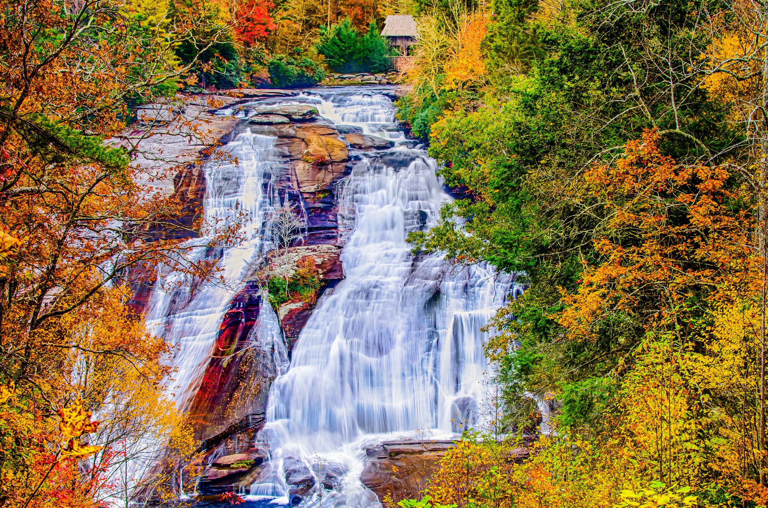 A multi-tiered waterfall surrounded by autumn foliage.