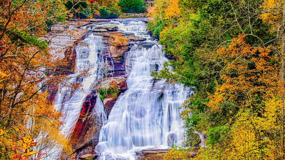 A multi-tiered waterfall surrounded by autumn foliage.