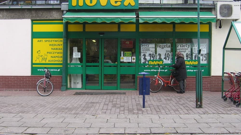 Une devanture de magasin aux couleurs vert et jaune, où le logo « noVex » est bien visible.
