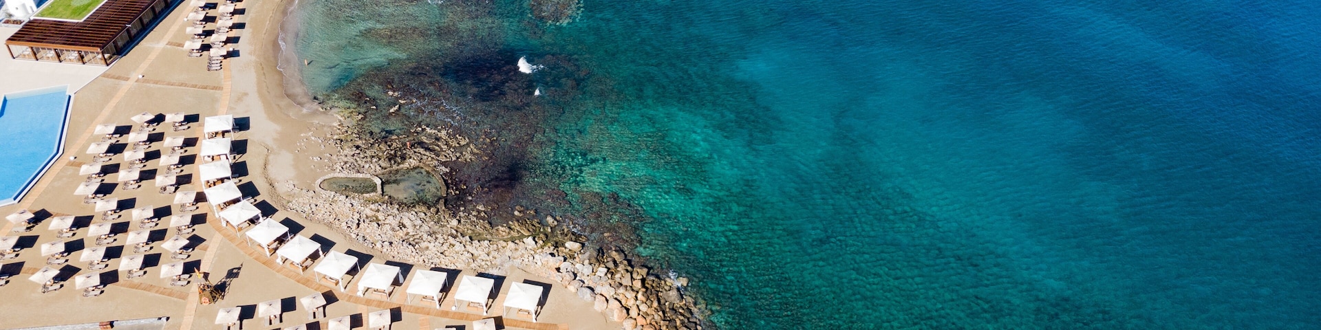 Beach off the coast of Crete in Hersonissos Greece. Seaside landscape. Rocky shore and sea.Bay off the coast. Summer sea and tourism. view from above