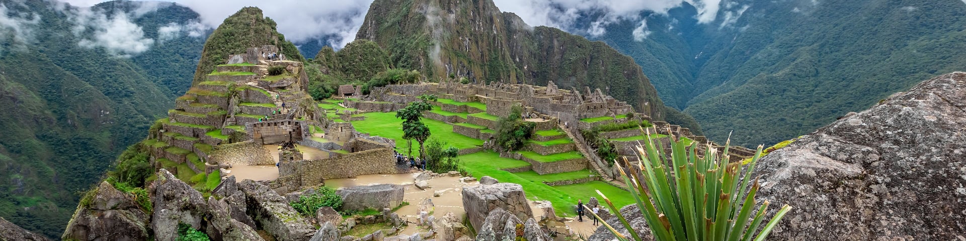 Machu Picchu, an ancient Incan city with terraced fields and stone structures, surrounded by misty mountains.