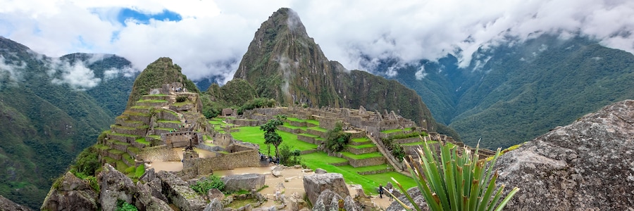 Machu Picchu, an ancient Incan city with terraced fields and stone structures, surrounded by misty mountains.