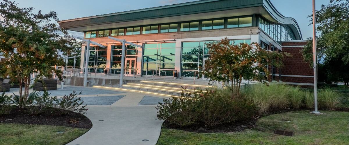A modern building with a green roof and large windows.