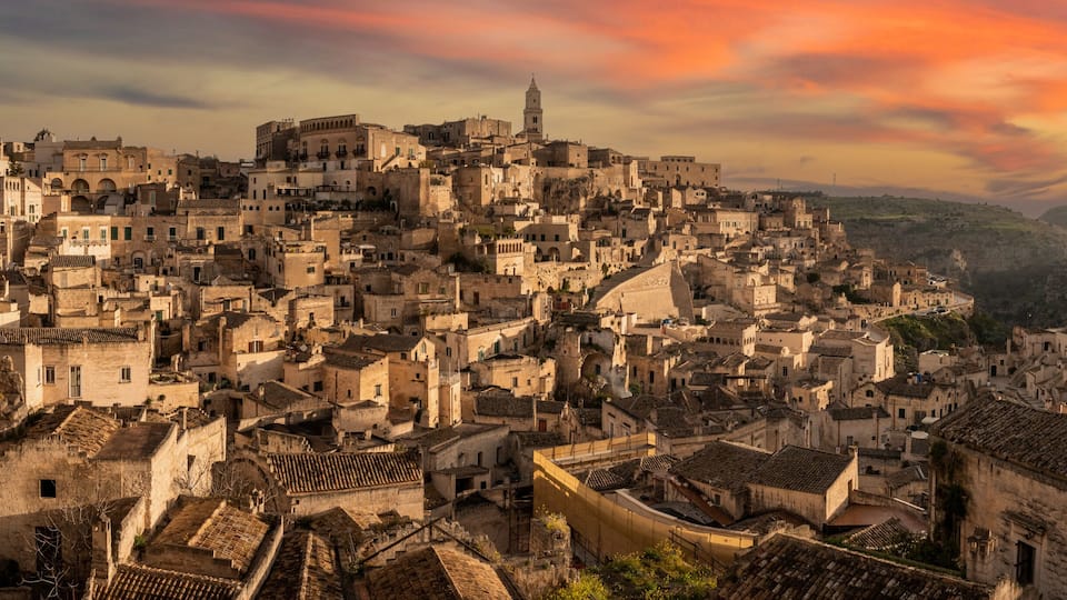 A densely packed historic town with medieval architecture, steep streets, and a prominent church tower.