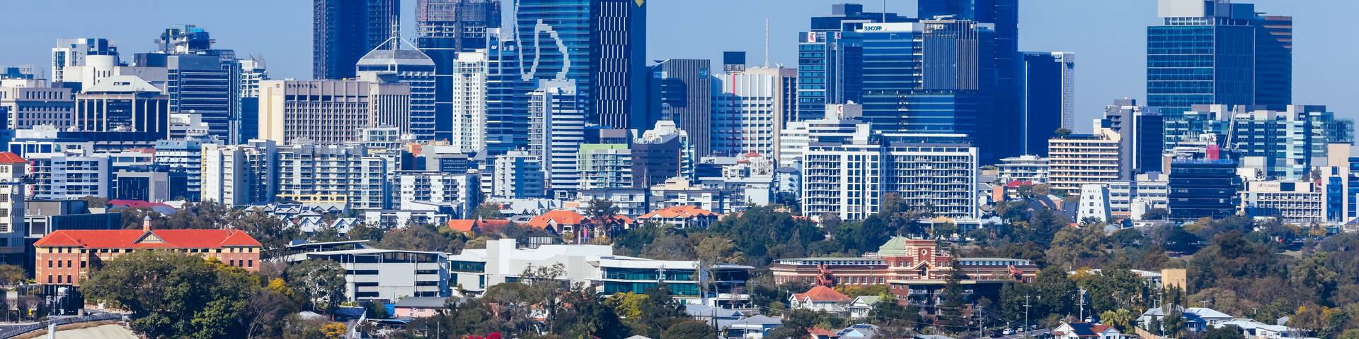 A city skyline with modern skyscrapers and a mix of residential houses.