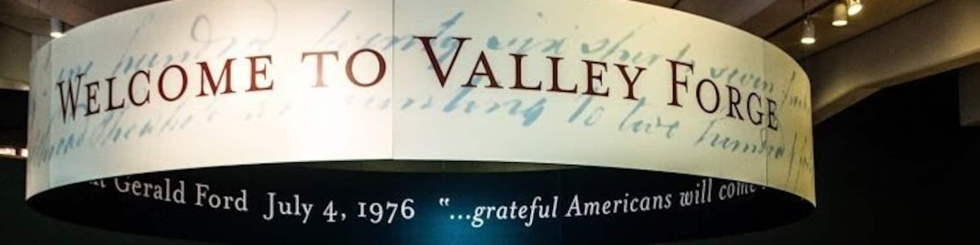 A curved sign with 'WELCOME TO VALLEY FORGE' and a quote by Gerald Ford.