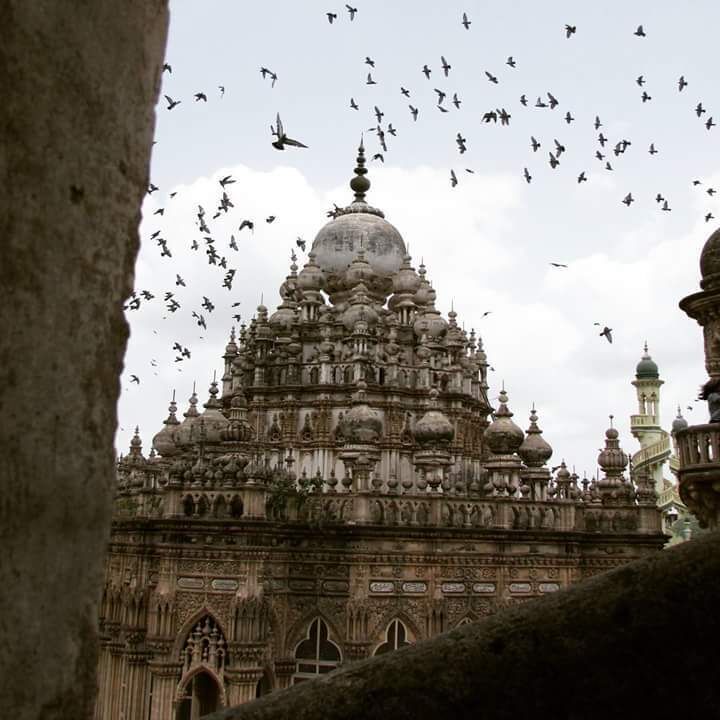 The best of earth can be seen through the tiniest of cracks. 
I took this photo from a tiny window in one of the minars and the birds came flying in at that very instant and added drama to the beautiful Tomb. The sultry skies of the monsoon had their share of play in making it perfect.
#InsideTravellersShoes